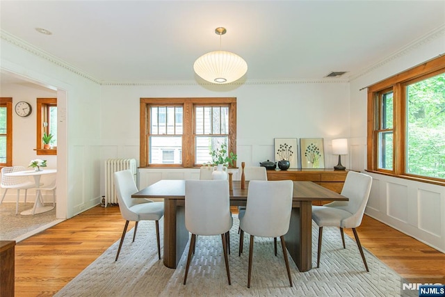 27 Nassau Rd, Montclair, NJ 07043 - dining space featuring radiator heating unit, light wood finished floors, a decorative wall, and a wainscoted wall