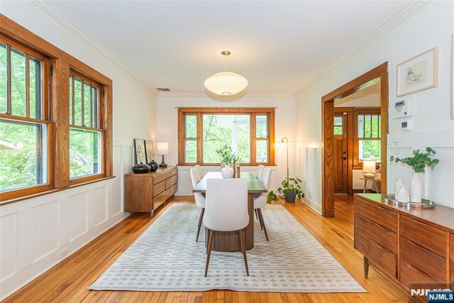27 Nassau Rd, Montclair, NJ 07043 - dining area with light wood-type flooring, a decorative wall, wainscoting, and crown molding
