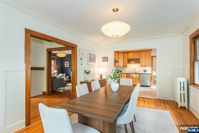 27 Nassau Rd, Montclair, NJ 07043 - dining room with radiator, light wood-style floors, crown molding, a wainscoted wall, and a decorative wall