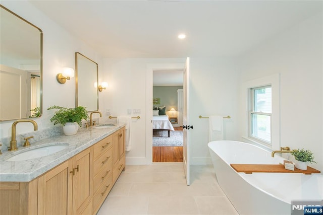 27 Nassau Rd, Montclair, NJ 07043 - ensuite bathroom with double vanity, a freestanding bath, tile patterned floors, baseboards, and recessed lighting
