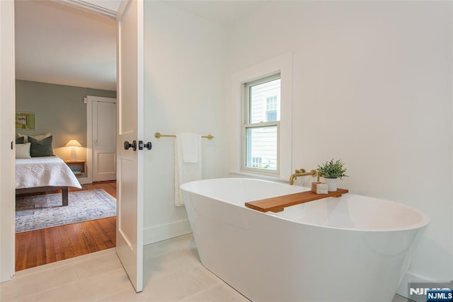 27 Nassau Rd, Montclair, NJ 07043 - bathroom with a freestanding tub, connected bathroom, baseboards, and tile patterned floors