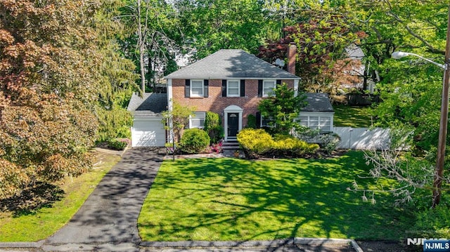 12 Louise Ln, Tenafly, NJ 07670 - colonial-style house with an attached garage, brick siding, a chimney, driveway, and roof with shingles