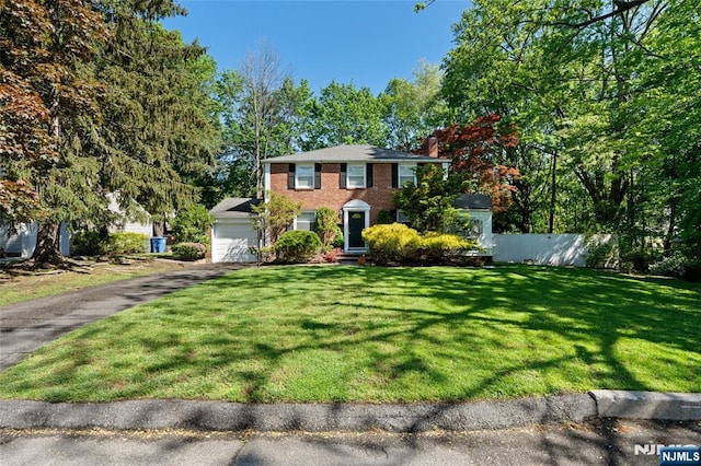 12 Louise Ln, Tenafly, NJ 07670 - colonial-style house with a garage, driveway, a chimney, and brick siding