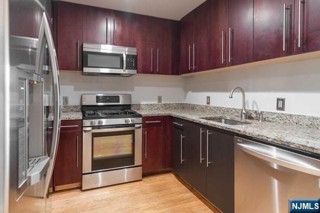 812 Hudson Park Unit 812, Edgewater, NJ 07020 - kitchen with stainless steel appliances, a sink, dark brown cabinets, and light stone countertops