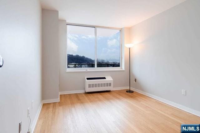 812 Hudson Park Unit 812, Edgewater, NJ 07020 - spare room featuring radiator heating unit, wood finished floors, and baseboards