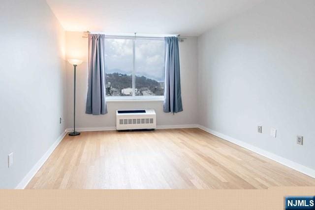 812 Hudson Park Unit 812, Edgewater, NJ 07020 - spare room with radiator heating unit, wood finished floors, and baseboards
