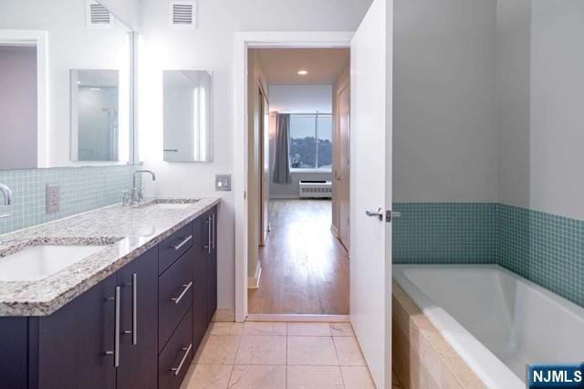 812 Hudson Park Unit 812, Edgewater, NJ 07020 - bathroom with double vanity, radiator heating unit, a garden tub, and baseboards