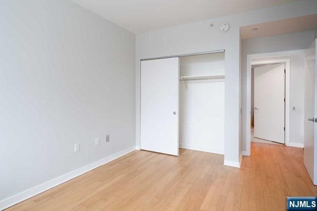 812 Hudson Park Unit 812, Edgewater, NJ 07020 - unfurnished bedroom with light wood-type flooring, a closet, and baseboards