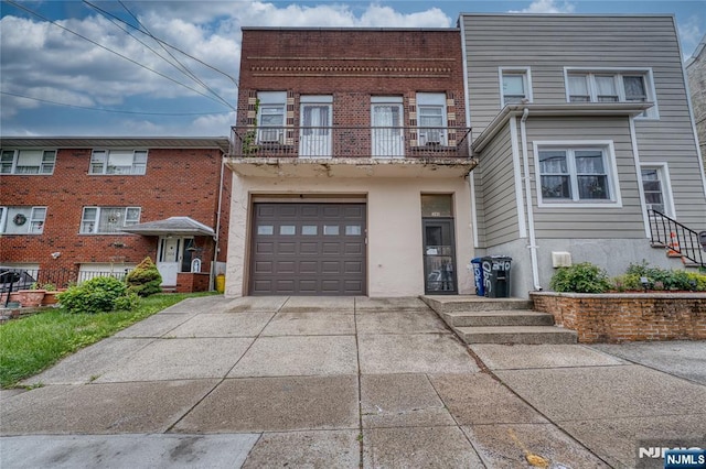 390 Delano Pl, Fairview, NJ 07022 - townhome / multi-family property with concrete driveway, a garage, a balcony, and brick siding