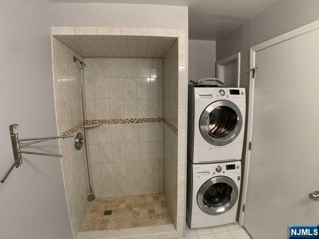 18 Prospect St Unit 4, Palisades Park, NJ 07650 - bathroom featuring stacked washer / dryer, a tile shower, and tile patterned floors