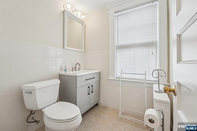 74 Oakdene Ave, Cliffside Park, NJ 07010 - bathroom featuring tile walls, toilet, vanity, tile patterned flooring, and a wainscoted wall