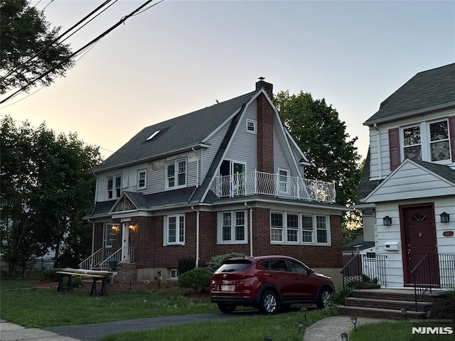 217 Grayson Pl, Teaneck, NJ 07666 - view of front of home with a chimney, a balcony, a yard, and brick siding