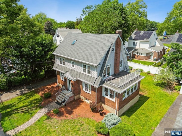 217 Grayson Pl, Teaneck, NJ 07666 - view of front of property featuring a balcony, a chimney, brick siding, a front yard, and roof with shingles