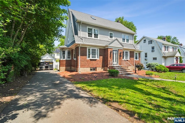 217 Grayson Pl, Teaneck, NJ 07666 - view of front of property with brick siding, a front yard, an outbuilding, and driveway