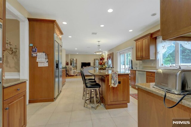 245 Forest Ave, Emerson, NJ 07630 - kitchen featuring open floor plan, brown cabinetry, a breakfast bar area, recessed lighting, and stainless steel appliances