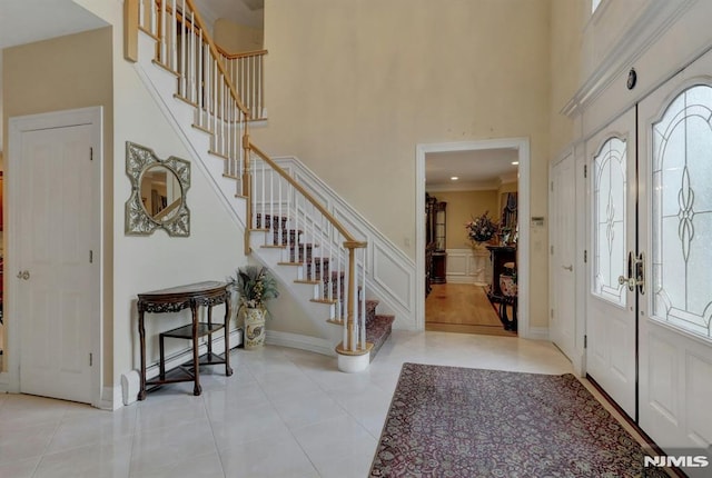 245 Forest Ave, Emerson, NJ 07630 - tiled entryway featuring plenty of natural light, stairs, a high ceiling, a decorative wall, and wainscoting