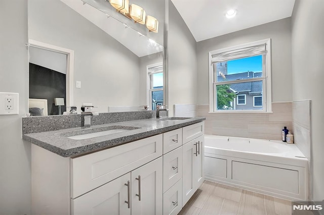 274 Roslyn Ct, West New York, NJ 07093 - bathroom featuring vaulted ceiling, double vanity, and a bath