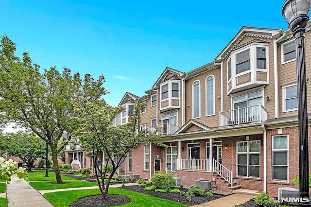 274 Roslyn Ct, West New York, NJ 07093 - view of front facade with brick siding, central AC, and covered porch