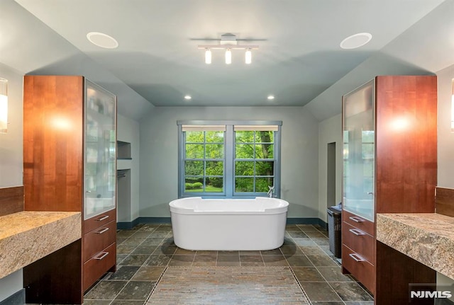 275 Gregory Rd, Franklin Lakes, NJ 07417 - full bath with vaulted ceiling, a freestanding bath, stone tile flooring, baseboards, and vanity