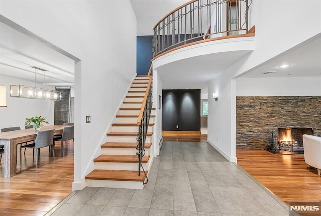 275 Gregory Rd, Franklin Lakes, NJ 07417 - stairs with a high ceiling, a stone fireplace, baseboards, and tile patterned floors
