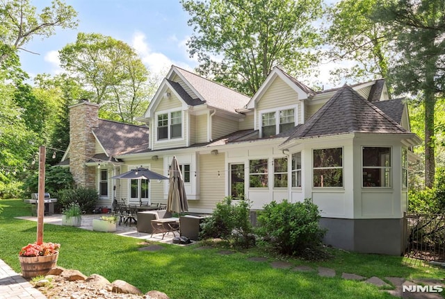 275 Gregory Rd, Franklin Lakes, NJ 07417 - view of front of property featuring roof with shingles, a patio, a front lawn, and a chimney