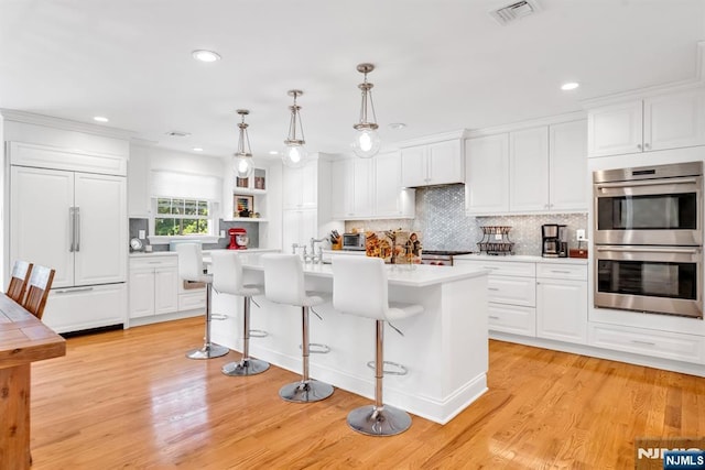 337 Vreeland Ave, Leonia, NJ 07605 - kitchen with stainless steel double oven, light countertops, paneled refrigerator, tasteful backsplash, and white cabinets