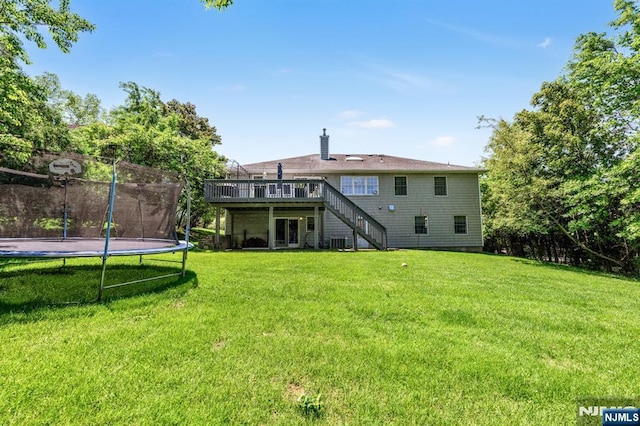 337 Vreeland Ave, Leonia, NJ 07605 - back of house with stairs, a wooden deck, a trampoline, a lawn, and cooling unit
