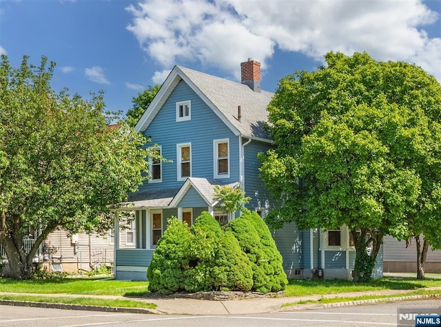 50 Richards Ave, Dover Town, NJ 07801 - view of front of property featuring a chimney, roof with shingles, and uncovered parking