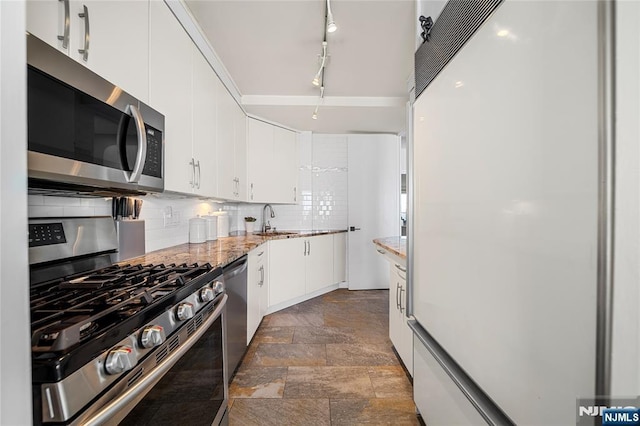 3 Horizon Unit 801, Fort Lee, NJ 07024 - kitchen featuring appliances with stainless steel finishes, a sink, decorative backsplash, white cabinets, and dark stone finish floors