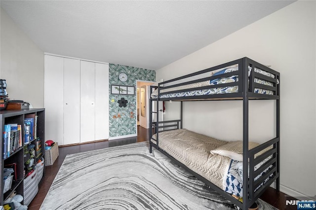 3 Horizon Unit 801, Fort Lee, NJ 07024 - bedroom with wallpapered walls, an accent wall, wood finished floors, a closet, and baseboards