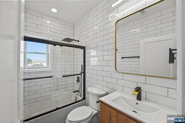 78 Schuyler Ave, North Arlington, NJ 07031 - full bathroom featuring tile walls, vanity, shower / bath combination with glass door, toilet, and backsplash
