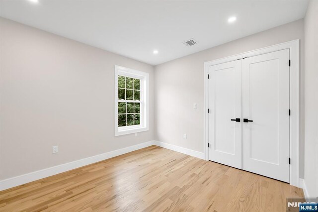 15 Monroe St, Garfield, NJ 07026 - unfurnished bedroom featuring light wood-style floors, baseboards, recessed lighting, and a closet