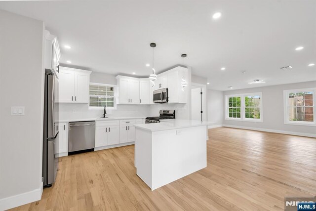 15 Monroe St, Garfield, NJ 07026 - kitchen with stainless steel appliances, a sink, open floor plan, light wood-style floors, and recessed lighting