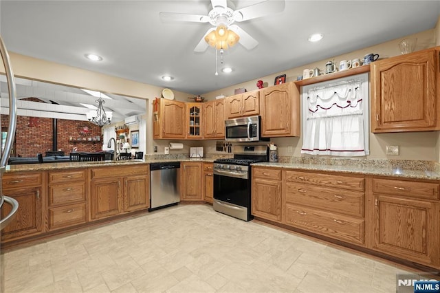 51 Sunrise Ter, Cedar Grove, NJ 07009 - kitchen with stainless steel appliances, a sink, a ceiling fan, brown cabinetry, and a chandelier