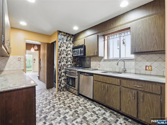 685 Maple Ave, Ridgefield, NJ 07657 - kitchen featuring stainless steel appliances, light countertops, decorative backsplash, a sink, and recessed lighting