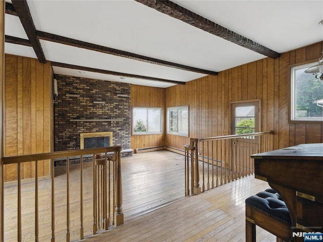 685 Maple Ave, Ridgefield, NJ 07657 - playroom with hardwood / wood-style flooring, beam ceiling, wooden walls, and a brick fireplace