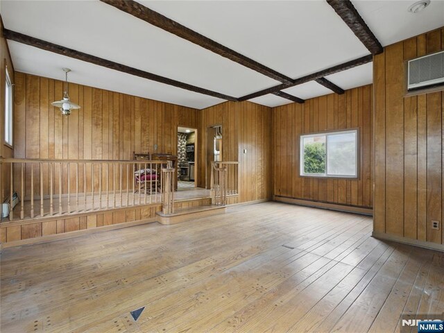 685 Maple Ave, Ridgefield, NJ 07657 - unfurnished living room with baseboard heating, beamed ceiling, wood-type flooring, and wooden walls