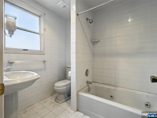 685 Maple Ave, Ridgefield, NJ 07657 - bathroom with toilet, tile walls, a combined bath / shower with jetted tub, tile patterned flooring, and a sink