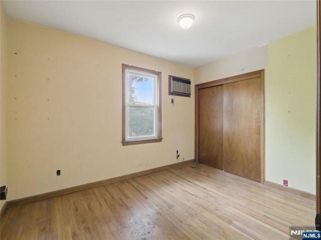 685 Maple Ave, Ridgefield, NJ 07657 - unfurnished bedroom with hardwood / wood-style flooring, a closet, baseboards, and a wall mounted AC