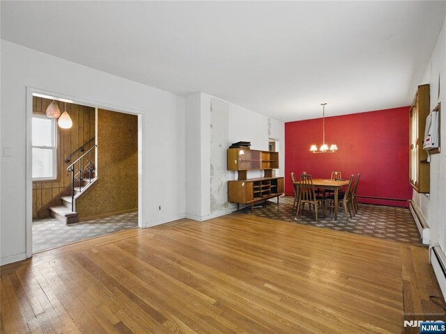 685 Maple Ave, Ridgefield, NJ 07657 - dining area featuring wood-type flooring, a chandelier, stairway, a baseboard radiator, and a baseboard heating unit