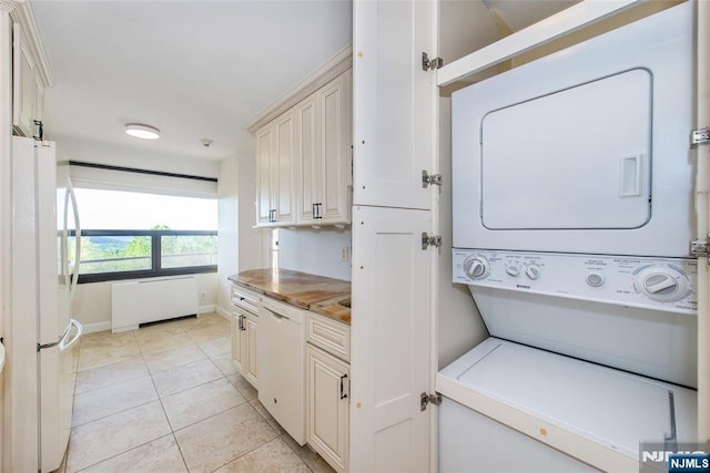 2 Clairidge Unit 3Nw, Verona, NJ 07044 - laundry room featuring stacked washer / dryer, baseboards, light tile patterned floors, and radiator