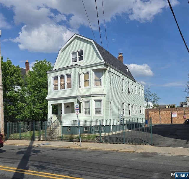 678 Grove St, Irvington, NJ 07111 - dutch colonial featuring a chimney, a fenced front yard, and a porch