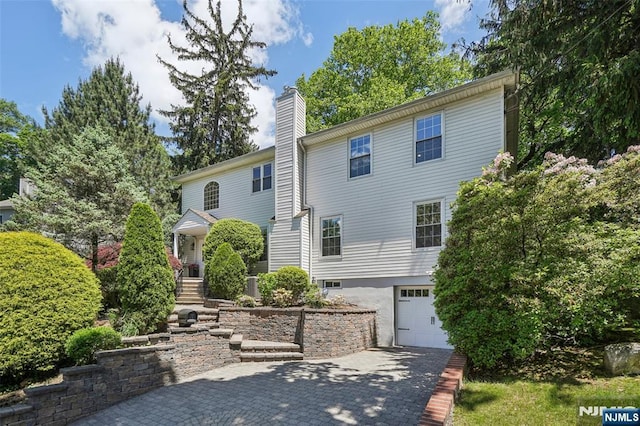 43 Lawrence Pkwy, Tenafly, NJ 07670 - view of front of house featuring a garage, a chimney, and decorative driveway