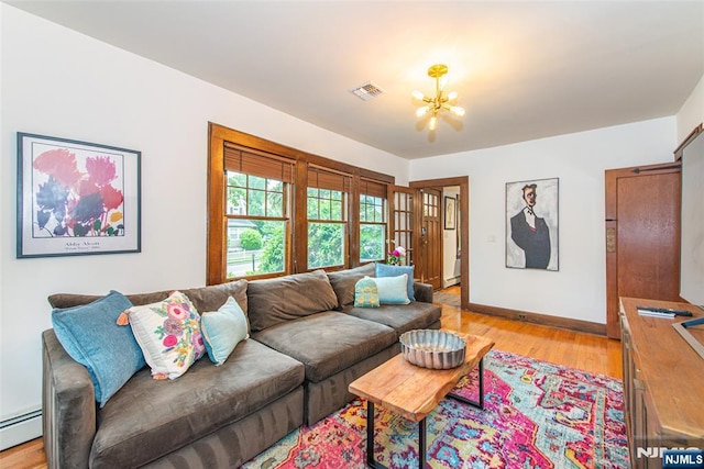 449 E Valley Rd, Montclair, NJ 07043 - living area with a chandelier, a baseboard heating unit, light wood finished floors, and baseboards