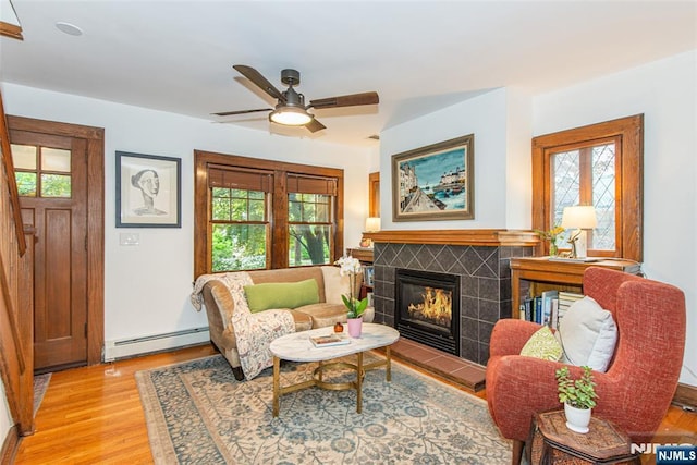 449 E Valley Rd, Montclair, NJ 07043 - living area with a baseboard radiator, light wood-style floors, ceiling fan, and a tiled fireplace