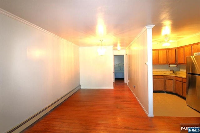 729 10th St Unit 3D, Secaucus, NJ 07094 - hallway featuring baseboard heating, a sink, light wood-style floors, ornamental molding, and baseboards