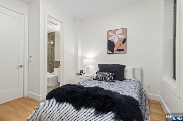 50 Grace St Unit 2R, Jersey City, NJ 07307 - bedroom featuring light wood-style floors, baseboards, and connected bathroom