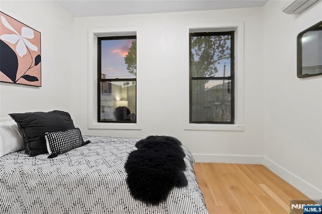 50 Grace St Unit 2R, Jersey City, NJ 07307 - sitting room featuring an AC wall unit, wood finished floors, and baseboards