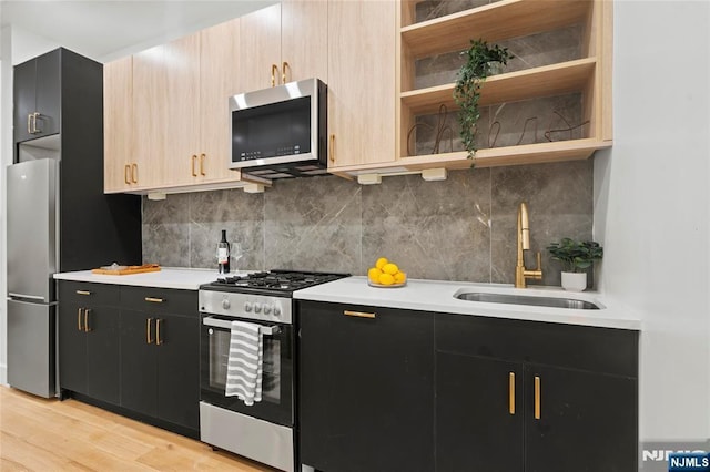 50 Grace St Unit 2R, Jersey City, NJ 07307 - kitchen featuring stainless steel appliances, a sink, dark cabinetry, and light countertops
