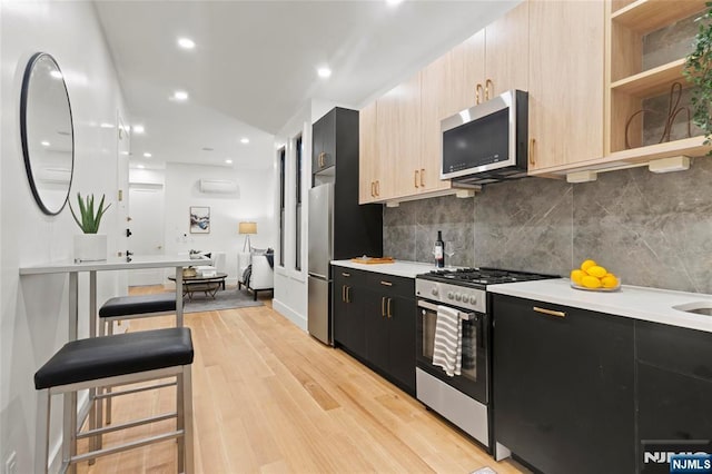 50 Grace St Unit 2R, Jersey City, NJ 07307 - kitchen featuring appliances with stainless steel finishes, dark cabinetry, light countertops, backsplash, and recessed lighting